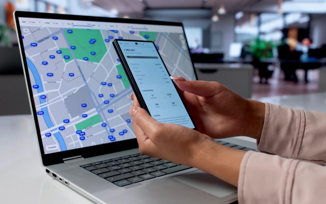Property manager using a laptop map and smartphone to coordinate maintenance vendors